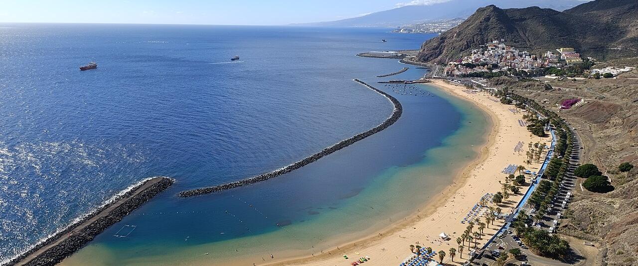 Golden sand of Playa de Las Teresitas curving along a calm blue bay on Tenerife