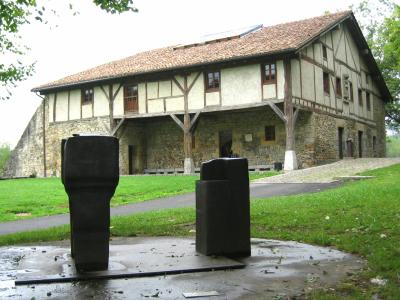 Chillida's iron sculptures on the lawn before the Zabalaga farmhouse at Chillida Leku