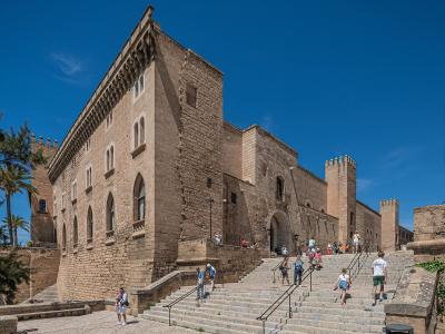 The stone facade of the Royal Palace of La Almudaina above the steps in Palma
