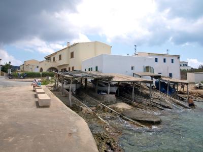 Fishermen's boat sheds along the rocky shore of Es Caló, Formentera