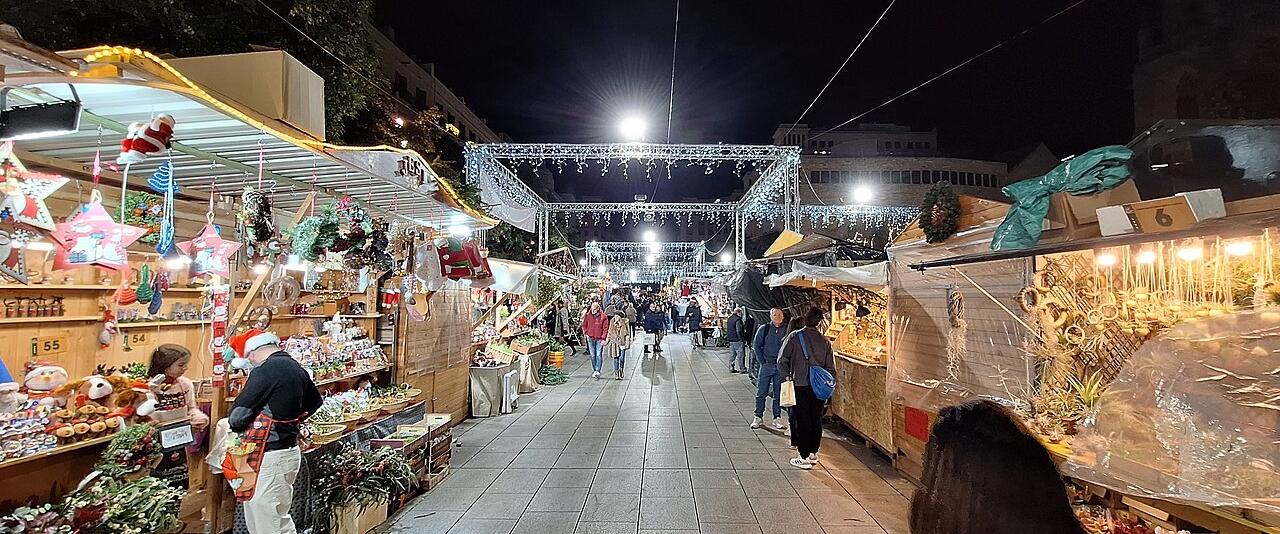 Stalls lit up at night at the Fira de Santa Llúcia Christmas market in Barcelona
